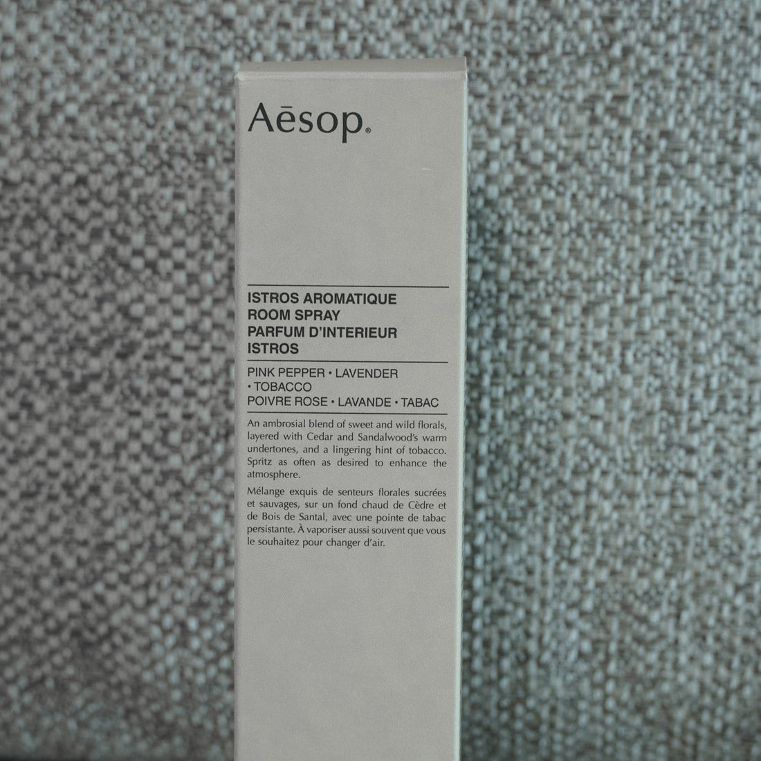 Aesop product packaging on a textured gray background