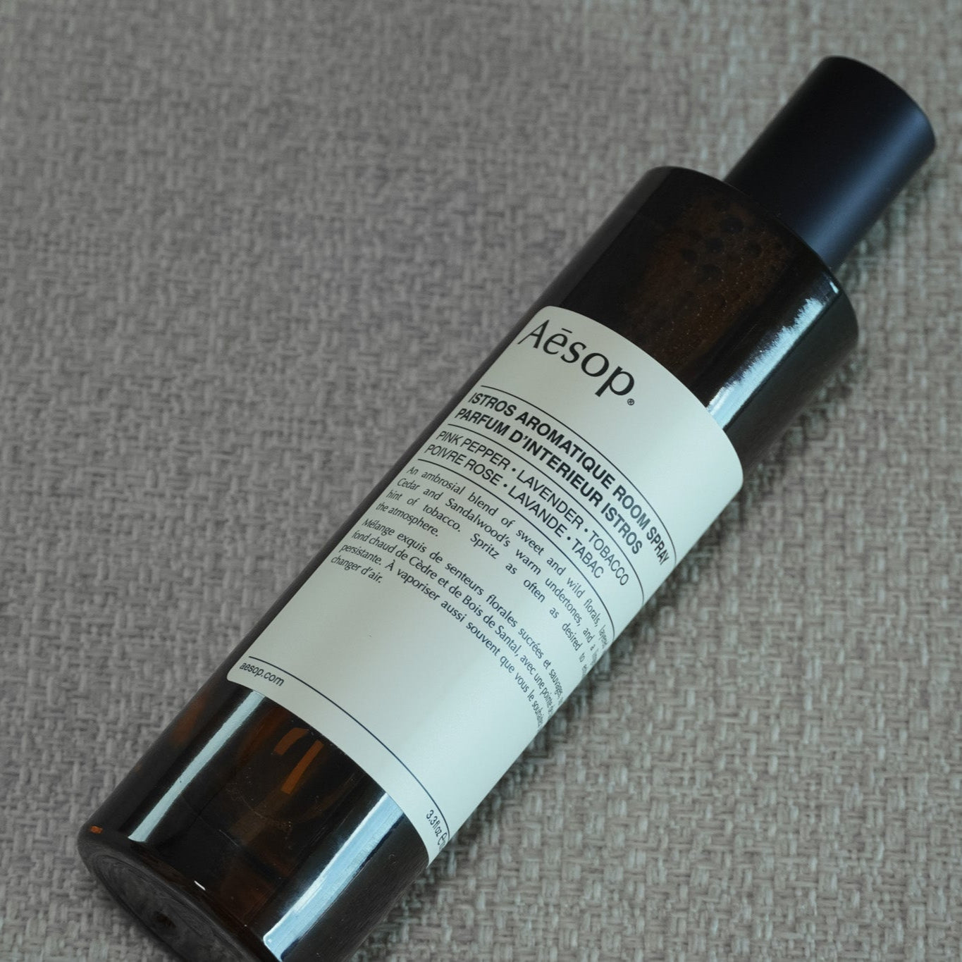 Aesop bottle on a textured gray background